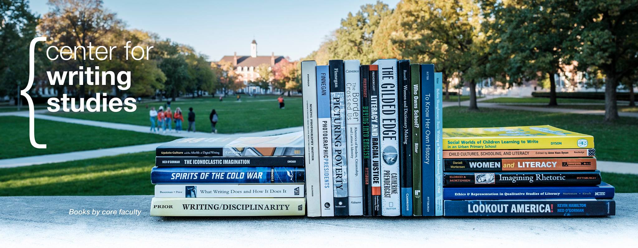 Banner image depicting a view UIUC quad from Foellinger Auditorium in the background, with students walking by. In the foreground, a stack of books by Center for Writing Studies faculty is visible, half of them propped up vertically by surrounding horizontal stacks. The caption reads "books by core faculty." The Center for Writing Studies logo is visible in the upper left: a large brace bracket that surrounds white text, "center for writing studies."
